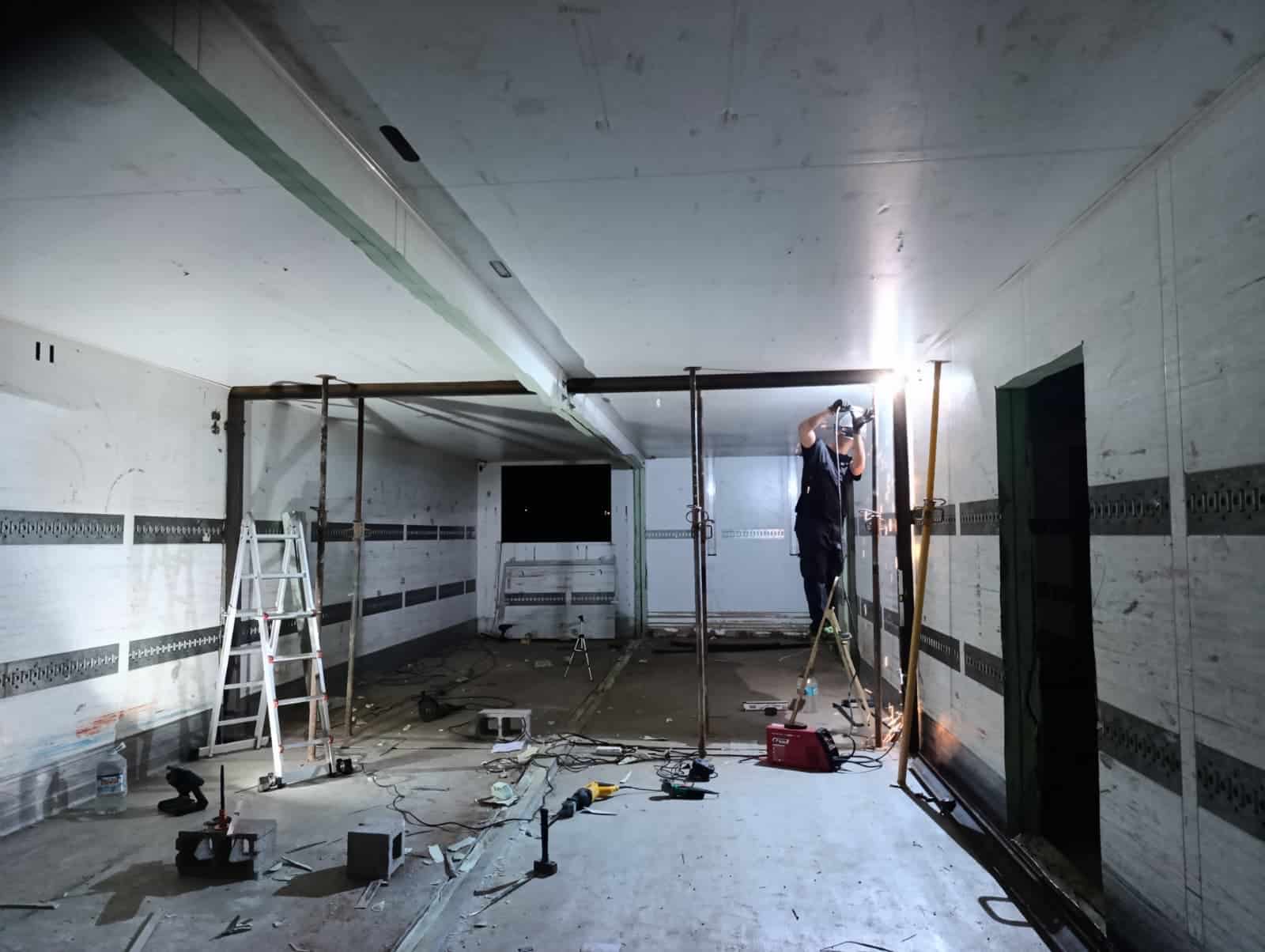 Refuerzo de vigas en proceso dentro de una casa modular, con puntales provisionales